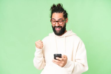 Young man with beard over isolated chroma key background surprised and sending a message