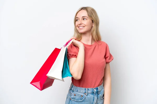 若い英語の女性は白い背景にショッピングバッグを保持し 振り返って孤立 — ストック写真