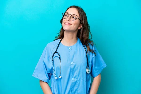 Junge Chirurgin Ärztin Isoliert Auf Blauem Hintergrund Denkt Eine Idee — Stockfoto