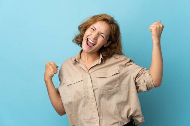 Genç Gürcü kadın mavi arka planda tek başına zaferi kutluyor.