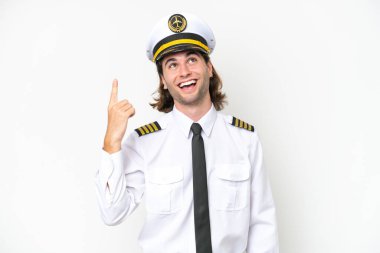 Yakışıklı uçak pilotu beyaz arka planda izole edilmiş yukarı bakıyor ve şaşırıyor