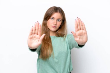 Beyaz arka planda izole edilmiş genç beyaz kadın dur hareketi yapıyor ve hayal kırıklığına uğruyor.