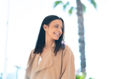 Açık havada genç bir kadın Neşeli bir ifadeyle