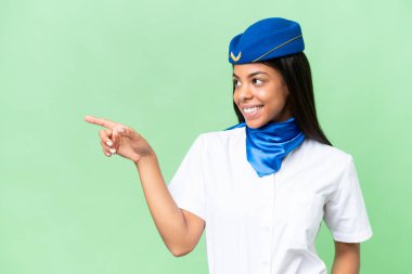 Uçak hostesi Afrikalı Amerikalı kadın izole edilmiş arka planda parmak göstererek bir ürün sunuyor.