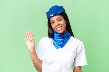 Uçak hostesi Afro-Amerikan kadın izole edilmiş arka planda mutlu bir ifadeyle selam veriyor.