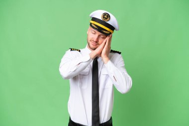 Uçak pilotu izole edilmiş arka planda uyku jesti yapıyor.