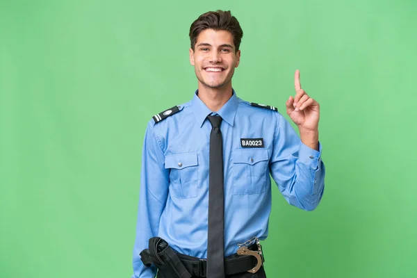 Młody Policjant Odosobnionym Tle Pokazujący Podnoszący Palec Znak Najlepszego — Zdjęcie stockowe