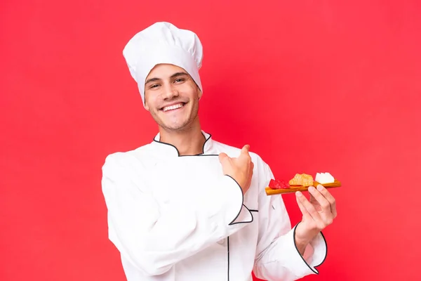 Jovem Chef Caucasiano Homem Segurando Sashimi Isolado Fundo Vermelho Apontando — Fotografia de Stock