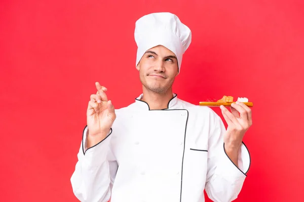 Junge Kaukasische Koch Mann Hält Sashimi Isoliert Auf Rotem Hintergrund — Stockfoto