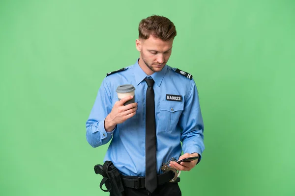 Молодой Полицейский Изолированном Фоне Кофе Руках Мобильным Телефоном — стоковое фото