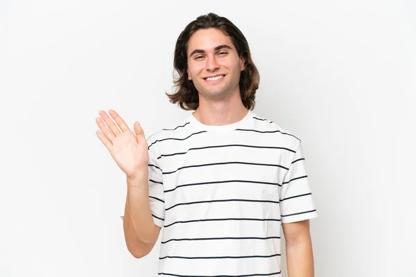 stock image Young handsome man isolated on white background saluting with hand with happy expression