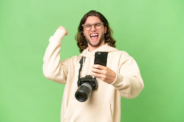 Jeune Photographe Homme Sur Fond Isolé Avec Téléphone Position Victoire — Photo