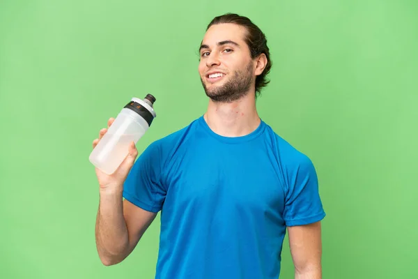 年轻英俊男子与运动水瓶的绿色背景隔离 — 图库照片