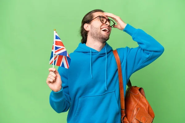 年轻英俊的男子举着英国国旗 背景孤寂 面带微笑 — 图库照片