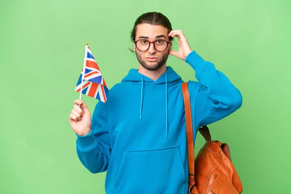 年轻英俊男子举着英国国旗 背景偏僻 令人怀疑 — 图库照片
