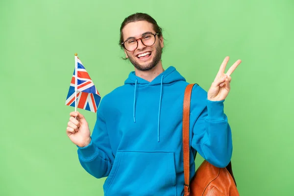 Młody Przystojny Mężczyzna Trzyma Flagę Wielkiej Brytanii Odosobnionym Tle Uśmiechając — Zdjęcie stockowe