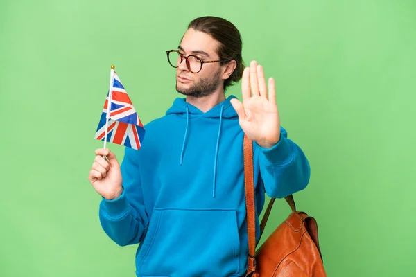 年轻英俊的男子举着英国国旗 在孤立的背景下做着停止姿势 感到失望 — 图库照片