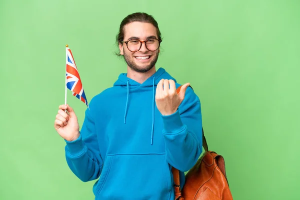 年轻英俊的男子举着英国国旗 背景偏僻 受邀携起手来 很高兴你来了 — 图库照片