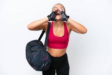 Young sport woman with sport bag isolated on white background shouting and announcing something