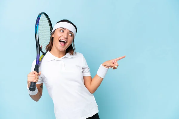 Young Tennis Player Woman Isolated Blue Background Pointing Finger Side — Stok fotoğraf