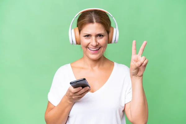 Middelbare Leeftijd Kaukasische Vrouw Geïsoleerde Achtergrond Luisteren Muziek Met Een — Stockfoto