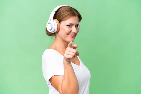 Middle Aged Caucasian Woman Isolated Background Listening Music Pointing Front — Stock Photo, Image