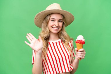 Kornet dondurması ile izole edilmiş arka planda genç bir İngiliz kadını mutlu bir ifadeyle selamlıyor.