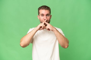 Yeşil krom arka planda izole edilmiş yakışıklı beyaz adam sessizlik işareti gösteriyor.