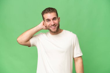 Yeşil krom arka planda izole edilmiş yakışıklı beyaz adam gülüyor.