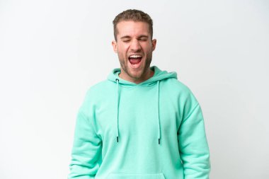 Beyaz arka planda izole edilmiş yakışıklı beyaz adam ağzı açık bir şekilde öne doğru bağırıyor.