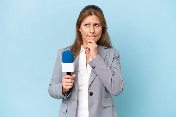 Zole Edilmiş Mavi Arka Planda Orta Yaşlı Televizyon Sunucusu Kadının — Stok fotoğraf