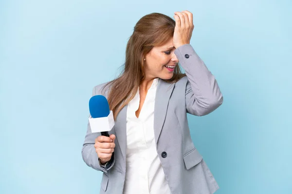 Zole Edilmiş Mavi Arka Plandaki Orta Yaşlı Televizyon Sunucusu Kadın — Stok fotoğraf