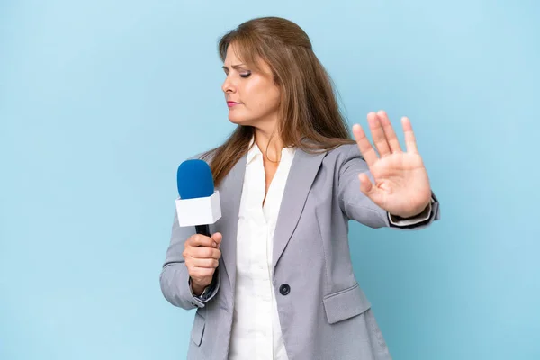 中年电视主持人女性对孤立的蓝色背景做出的停止动作和失望 — 图库照片