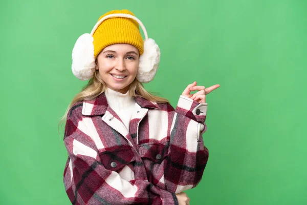 Jovem Inglesa Mulher Vestindo Inverno Muffs Sobre Isolado Fundo Apontando — Fotografia de Stock