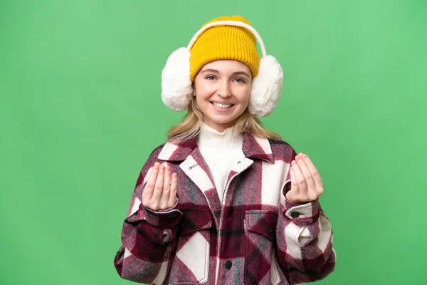 年轻的英国女人披着冬衣 背景偏僻 做着赚钱的姿势 — 图库照片