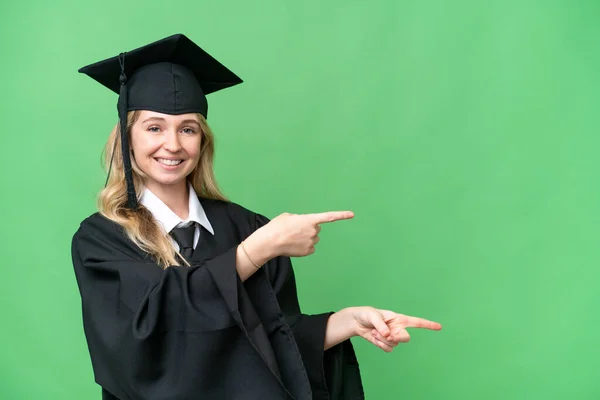 若い大学英語の大学院生の女性は 孤立した背景を指で側面に向け 製品を提示 — ストック写真