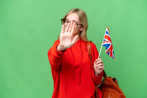 年轻的惊慌失措的女人举着英国国旗 在孤立无援的背景下做着停止姿势 感到失望 — 图库照片