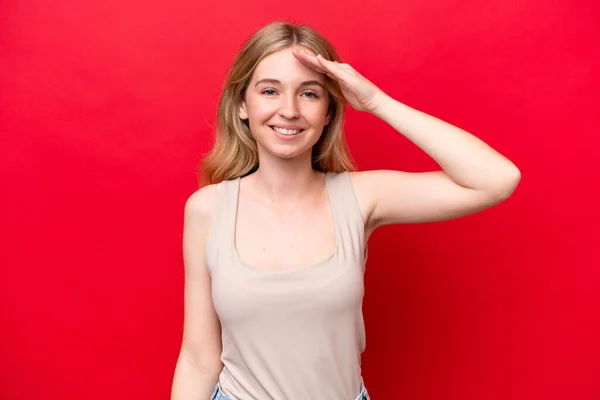 Junge Engländerin Auf Rotem Hintergrund Salutiert Mit Fröhlichem Gesichtsausdruck — Stockfoto