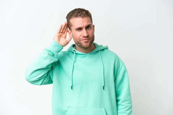 stock image Young handsome caucasian man isolated on white background listening to something by putting hand on the ear