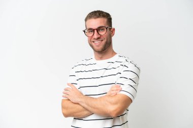 Beyaz arka planda soyutlanmış, kolları çapraz ve ileriye bakan yakışıklı beyaz bir adam.