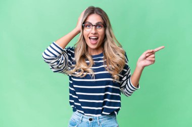 Genç Uruguaylı kadın izole bir arka planda şaşkın şaşkın ve işaret ediyor.