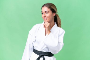 Genç Uruguaylı kadın izole edilmiş arka planda karate yapıyor. Yana bakıyor ve gülümsüyor.