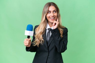 Genç, güzel Uruguaylı televizyon sunucusu, izole edilmiş arka planda bir fikir ararken,