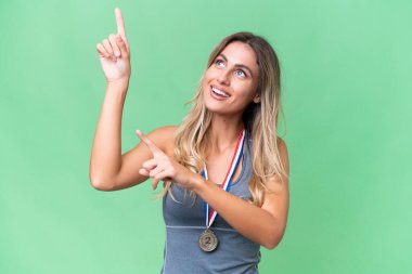 Young pretty sport Uruguayan woman with medals over isolated background pointing with the index finger a great idea clipart