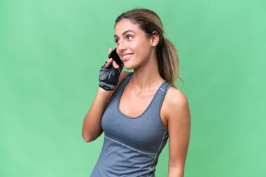 Güzel Sport Uruguaylı kadın izole bir arka planda cep telefonuyla sohbet ediyor.