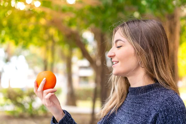 Молодая Красивая Румынская Женщина Держит Апельсин Открытом Воздухе Счастливым Выражением — стоковое фото