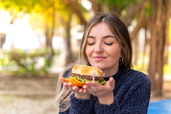 Young Pretty Romanian Woman Holding Burger Outdoors — Stock Photo, Image