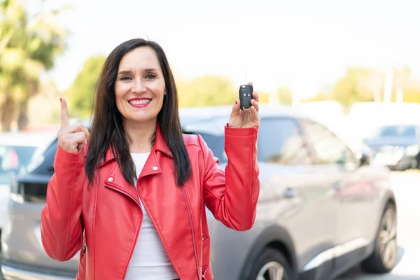Μεσήλικη Γυναίκα Κρατώντας Κλειδιά Του Αυτοκινήτου Εξωτερικούς Χώρους Επισημαίνοντας Μια — Φωτογραφία Αρχείου
