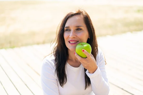 Žena Středního Věku Drží Jablko Šťastným Výrazem — Stock fotografie