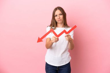 Genç Litvanyalı bir kadın pembe arka planda izole edilmiş, aşağıya doğru ok atıyor ve üzgün bir ifadeyle